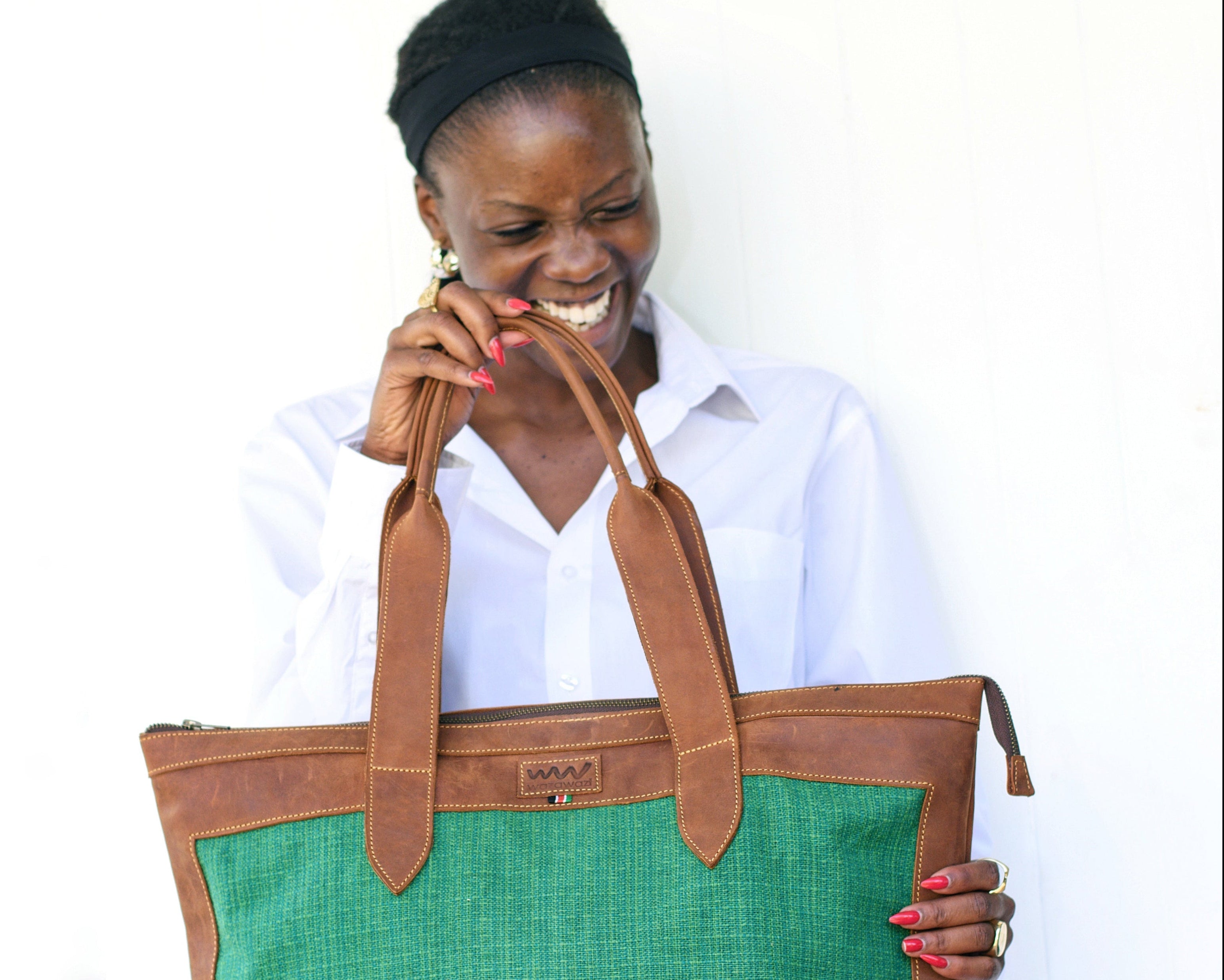 Woman holding a green and brown tote bag against a white background
